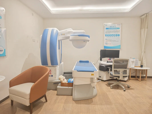 Magnetically controlled capsule gastroscopy room at Taikang Qianhai Hospital in Shenzhen, with the robotic magnet unit above a padded examination table